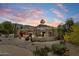 Stunning Santa Fe home showcasing desert landscaping, an elegant courtyard and a striking mountain backdrop at sunset at 9349 E Calle De Valle Dr, Scottsdale, AZ 85255