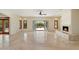 Bright living room with stone fireplace, tile flooring, open floor plan, and outdoor view through French doors to the pool at 9349 E Calle De Valle Dr, Scottsdale, AZ 85255