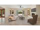 Bright living room with stone fireplace, tile flooring, open floor plan, and outdoor view through French doors to the pool at 9349 E Calle De Valle Dr, Scottsdale, AZ 85255