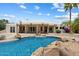Backyard swimming pool with rock features and a stone patio, perfect for outdoor relaxation at 9349 E Calle De Valle Dr, Scottsdale, AZ 85255