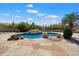 Beautiful pool area features rock features, lush vegetation, and stone tiling at 9349 E Calle De Valle Dr, Scottsdale, AZ 85255