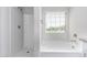 Bathroom with combined shower and tub with a window and bright white fixtures at 935 E Agua Fria Ln, Avondale, AZ 85323