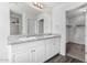 Bright bathroom featuring double sinks, a vanity with storage, and a large mirror at 935 E Agua Fria Ln, Avondale, AZ 85323
