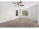 Bedroom with carpeted floors, ceiling fan and two windows at 935 E Agua Fria Ln, Avondale, AZ 85323