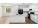 Modern kitchen boasts white cabinets, black appliances, and a granite-topped island, perfect for cooking at 935 E Agua Fria Ln, Avondale, AZ 85323