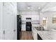 Bright modern kitchen features stainless steel sink and white cabinets, paired with black appliances at 935 E Agua Fria Ln, Avondale, AZ 85323