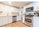 Contemporary kitchen with stainless steel appliances, pristine white cabinets, and functional layout at 1001 W 19Th St, Tempe, AZ 85281