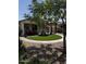 Landscaped backyard featuring a red umbrella seating area, artificial grass, and low-maintenance desert landscaping at 10704 E Twister Ave, Mesa, AZ 85212