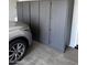 Garage with grey storage cabinets, parked car, and epoxy floor at 10704 E Twister Ave, Mesa, AZ 85212