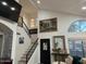 Bright living room featuring a fireplace, staircase, painting, and large window at 11028 W Crimson Ln, Avondale, AZ 85392