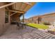 Serene backyard space with stone patio, artificial grass, and shaded seating areas at 11242 E Onza Ave, Mesa, AZ 85212