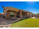 Spacious backyard featuring covered patio, outdoor dining set, and well-maintained artificial grass at 11242 E Onza Ave, Mesa, AZ 85212