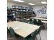 A spacious craft room equipped with large tables, chairs, and shelving units for hobbies and projects at 11242 E Onza Ave, Mesa, AZ 85212