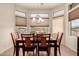 Well-lit dining room with large windows and a modern light fixture over the table at 11242 E Onza Ave, Mesa, AZ 85212