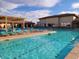 Luxurious community pool area featuring lounge chairs, pergola, and well-maintained landscaping at 11242 E Onza Ave, Mesa, AZ 85212