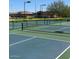 Community tennis courts with well-maintained nets and lines, surrounded by lush landscaping at 11242 E Onza Ave, Mesa, AZ 85212