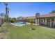 Aerial view of a spacious backyard featuring a pool, manicured lawn, covered patio, and mature trees, perfect for entertaining at 13593 N 91St Way, Scottsdale, AZ 85260