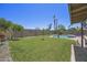 Expansive backyard with lush green grass, mature trees, desert landscaping, and an inviting in-ground pool for relaxation at 13593 N 91St Way, Scottsdale, AZ 85260