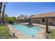 Inviting in-ground pool with sun loungers and a blue umbrella, surrounded by lush landscaping and a privacy wall at 13593 N 91St Way, Scottsdale, AZ 85260