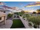 This backyard features a built-in BBQ, spa, artificial turf, and mature landscaping at 1398 W Windhaven Ave, Gilbert, AZ 85233