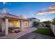 Beautiful backyard features a covered patio with a hot tub, low-maintenance landscaping, and an outdoor entertaining space at 1398 W Windhaven Ave, Gilbert, AZ 85233