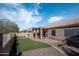 Relaxing backyard featuring artificial grass, a paved patio, an outdoor kitchen, and covered spa at 1398 W Windhaven Ave, Gilbert, AZ 85233