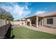 Relaxing backyard featuring artificial grass, a paved patio, an outdoor kitchen, and covered spa at 1398 W Windhaven Ave, Gilbert, AZ 85233