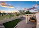 This backyard features a built-in BBQ, spa, artificial turf, and a partial view of a greenbelt at 1398 W Windhaven Ave, Gilbert, AZ 85233