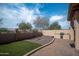 An inviting backyard with an outdoor kitchen, artificial turf, and paver patio at 1398 W Windhaven Ave, Gilbert, AZ 85233