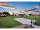 Outdoor basketball court surrounded by green space in a beautiful community with a stunning sunset sky at 1398 W Windhaven Ave, Gilbert, AZ 85233