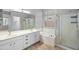 Bright bathroom features double sinks, soaking tub, a glass-enclosed shower, and neutral tiling at 1398 W Windhaven Ave, Gilbert, AZ 85233