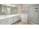 Bright bathroom features double sink vanity, tiled floors, glass enclosed shower, and a soaking tub at 1398 W Windhaven Ave, Gilbert, AZ 85233