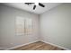 This simple bedroom features laminate flooring, neutral walls, and a ceiling fan at 1398 W Windhaven Ave, Gilbert, AZ 85233