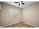Cozy bedroom with a ceiling fan, wood-look flooring, and natural light from the window at 1398 W Windhaven Ave, Gilbert, AZ 85233