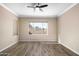 Bedroom featuring hardwood floors, a modern ceiling fan, and a window for natural light and backyard views at 1398 W Windhaven Ave, Gilbert, AZ 85233