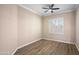 Cozy bedroom boasts hardwood floors, neutral paint, natural light from the window, and a ceiling fan at 1398 W Windhaven Ave, Gilbert, AZ 85233