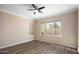 Bedroom features hardwood floors, a ceiling fan, and a large window providing backyard views and natural light at 1398 W Windhaven Ave, Gilbert, AZ 85233