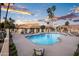 Relax poolside at the community pool featuring shaded seating areas, mature palm trees, and plenty of lounge chairs at 1398 W Windhaven Ave, Gilbert, AZ 85233