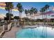 Community pool with shaded tables, playground, and palm trees offering a fun and relaxing outdoor space at 1398 W Windhaven Ave, Gilbert, AZ 85233