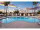Large community pool area with shade structures and lounge chairs, all surrounded by mature landscaping and community buildings at 1398 W Windhaven Ave, Gilbert, AZ 85233