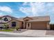 Tan home featuring a tile roof, well-maintained landscaping, and a two-car garage at 1398 W Windhaven Ave, Gilbert, AZ 85233