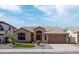 Tan home featuring a tile roof, well-maintained landscaping, and a two-car garage at 1398 W Windhaven Ave, Gilbert, AZ 85233