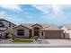 Tan home featuring a tile roof, well-maintained landscaping, and a two-car garage at 1398 W Windhaven Ave, Gilbert, AZ 85233