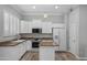Well-lit kitchen features white cabinetry, granite countertops, modern appliances, and wood-style flooring at 1398 W Windhaven Ave, Gilbert, AZ 85233
