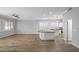 Bright living room with hardwood floors, white trim, shutters, ceiling fan and opens to the kitchen at 1398 W Windhaven Ave, Gilbert, AZ 85233