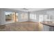 Bright living room with hardwood floors, white trim, shutters, ceiling fan and sliding door to the outdoor patio at 1398 W Windhaven Ave, Gilbert, AZ 85233