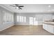 Bright living room with hardwood floors, white trim, shutters, ceiling fan and opens to the kitchen at 1398 W Windhaven Ave, Gilbert, AZ 85233