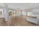 Bright living room with hardwood floors, white trim, shutters, ceiling fan and sliding door to the outdoor patio at 1398 W Windhaven Ave, Gilbert, AZ 85233