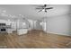 Spacious living room with wood-style flooring, a ceiling fan, and an open floor plan to the kitchen at 1398 W Windhaven Ave, Gilbert, AZ 85233
