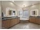 Luxurious bathroom with dual vanities, a soaking tub, and modern light fixtures at 14007 E Lupine Ave, Scottsdale, AZ 85259